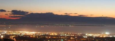 Άποψη της στιγμής λίγο πριν πέσει η νύχτα, στην Θεσσαλονίκη, από την Δυτική είσοδο της πόλης, με το λιμάνι και τον Θερμαϊκό κόλπο στο βάθος (Πηγή: Wikipedia).